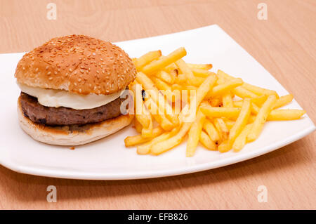 Hamburger et frites dans un oeuf Graines de sésame avec des jetons sur une plaque blanche Banque D'Images