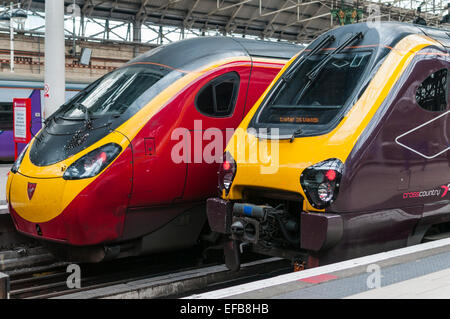 Virgin trains Pendolino et Cross Country Voyager high speed trains côte à côte à la gare Manchester Piccadilly Banque D'Images