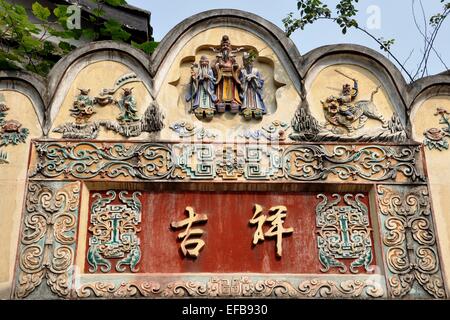 Chengdu, Chine : 18e siècle porte d'entrée avec panneau bas relief peint à la main, dessins de caractères chinois dans la Vieille Ville Banque D'Images