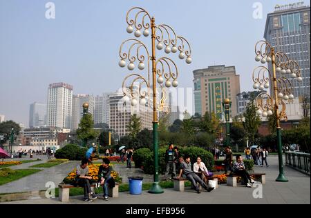 Chengdu, Chine : lampadaires dorés ornementaux et des jardins avec des sièges pour se détendre en Tianfu Square Banque D'Images