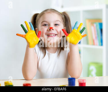 Portrait d'enfant fille avec le visage et les mains peints Banque D'Images