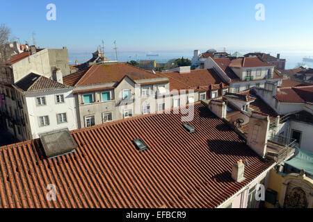 Une vue vers le Tage du Castello Sao Jorge à Lisbonne sur les toits avec la caractéristique de tuiles rouges portugais. Banque D'Images