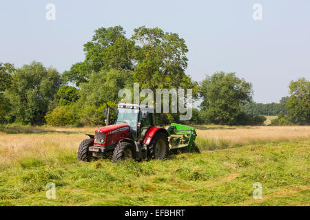 Tracteur et faucheuse à foin champ de tonte, Oxfordshire, Angleterre Banque D'Images