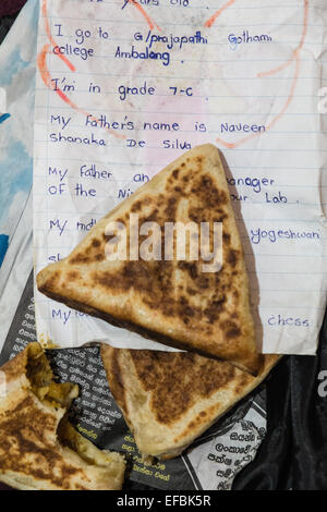 À Ville de Ella, Sri Lanka.sortir de cafe,samosa légumes roti a été servi enveloppé de vieux travaux scolaires English études imprimé. Banque D'Images