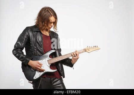 Jeune guitariste isolé sur gray Banque D'Images