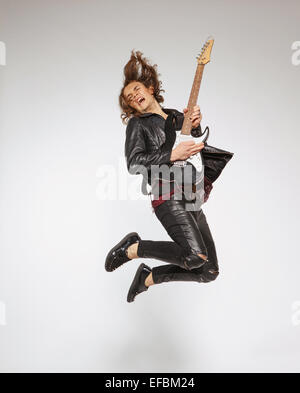 Jeune guitariste isolé sur gray Banque D'Images