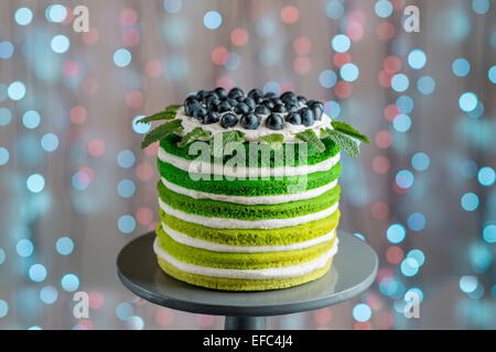 Belle éponge joyeux anniversaire avec gâteau mascarpone et raisins sur le stand de gâteaux de fête sur bokeh lumière Banque D'Images