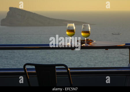 Verres de vin blanc avec des collations au bar sur le toit et vue sur l'île de paon, Benidorm, Costa Blanca, Espagne Banque D'Images