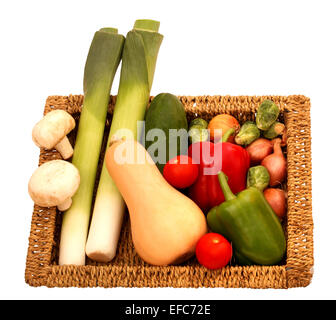 Un petit panier en osier plein de légumes cultivés sur un fond blanc Banque D'Images