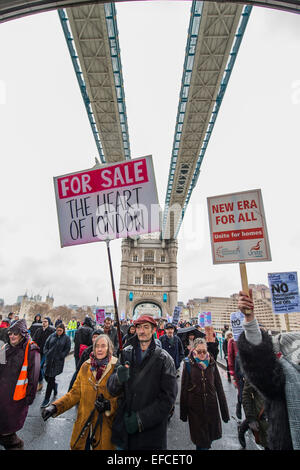 Londres, Royaume-Uni. Jan 31, 2015. Passant sur le Tower Bridge. Les gens ont marché depuis le sud de Londres et à l'Est de Londres à l'Hôtel de ville pour exiger l'amélioration des maisons pour les habitants de London et de mettre fin à la crise du logement. Ces revendications concernent le contrôle des loyers, abordables et sûres pour tous les foyers, un terme à la Chambre à coucher et du bien-être social de l'impôt des plafonds et la construction de nouveaux logements sociaux. L'événement a été appelé par la défense du logement et du Conseil de l'Assemblée populaire du sud de Londres. Et la route est de Londres a débuté à l'église paroissiale de Saint Leonard, Shoreditch, London, Royaume-Uni. 31 Jan 2015. Crédit : Guy Bell/Alamy Live News Banque D'Images