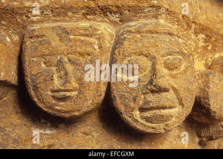 Naïve deux sculptures du 13ème siècle de visages sur archway en église Lincolnshire UK Banque D'Images