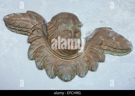 Peint d'or de la sculpture de la tête de chérubin géorgienne avec des ailes sur le mur peint en blanc Banque D'Images