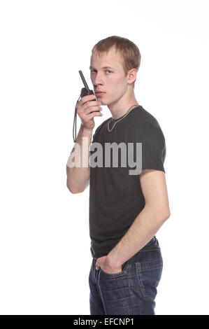 L'agent de sécurité les jeunes parler à travers son talkie walkie. Isolé sur fond blanc. Portrait demi-longueur. Banque D'Images