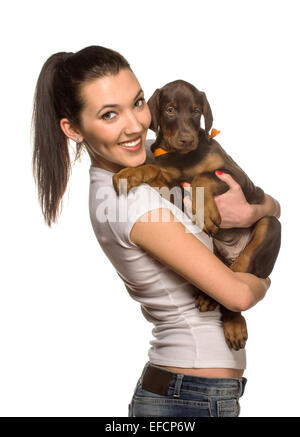 Brunette girl kissing her dobermann chiot isolé sur fond blanc Banque D'Images