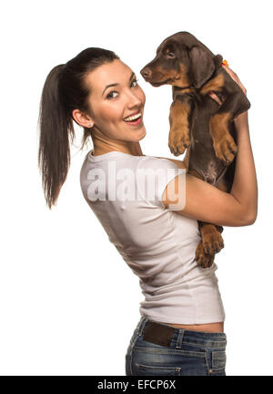 Brunette girl kissing her dobermann chiot isolé sur fond blanc Banque D'Images