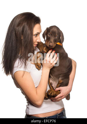 Brunette girl kissing her dobermann chiot isolé sur fond blanc Banque D'Images