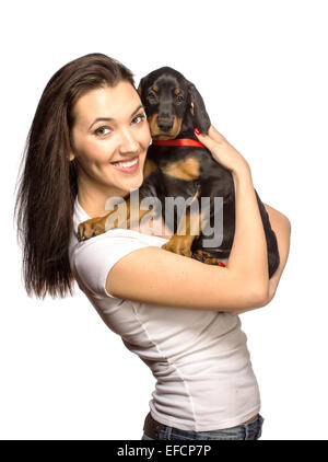 Brunette girl kissing her dobermann chiot isolé sur fond blanc Banque D'Images