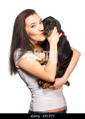 Brunette girl kissing her dobermann chiot isolé sur fond blanc Banque D'Images