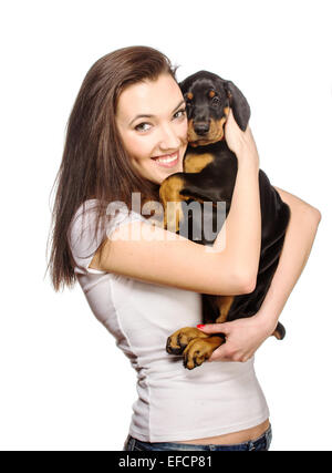 Brunette girl kissing her dobermann chiot isolé sur fond blanc Banque D'Images