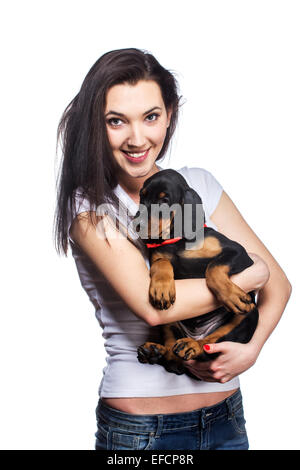 Brunette girl kissing her dobermann chiot isolé sur fond blanc Banque D'Images