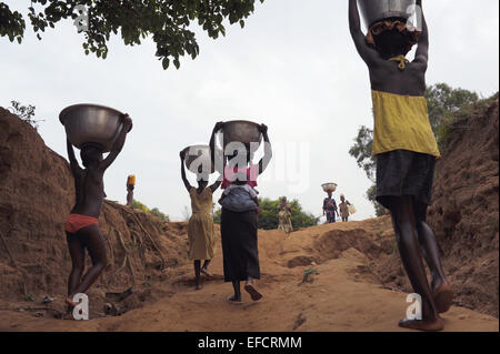 Les femmes et les enfants portant de l'eau du lac Volta, au Ghana. Banque D'Images