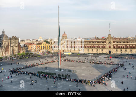 Foule rassemblée à Mexico Zocalo pour regarder les soldats & Bugle Corps dans tous les jours de cérémonie de l'abaissement du drapeau mexicain au coucher du soleil Banque D'Images