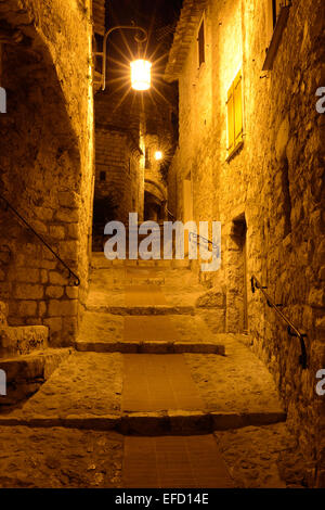 Allée illuminée dans la nuit dans un village médiéval.Èze-Village, Alpes-Maritimes, Côte d'Azur, France. Banque D'Images