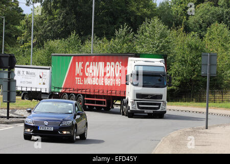 Les camions et une voiture roulant autour d'un rond-point à Coulsdon, Surrey, Angleterre Banque D'Images