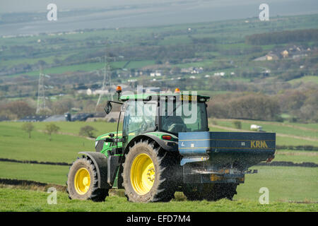 6126r John Deere répandre engrais sur les pâturages de montagne, Lancashire, Royaume-Uni. Banque D'Images