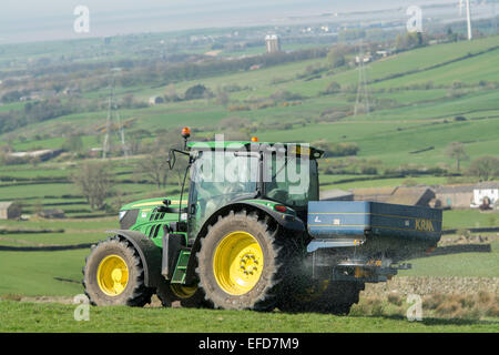 6126r John Deere répandre engrais sur les pâturages de montagne, Lancashire, Royaume-Uni. Banque D'Images