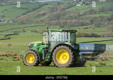 6126r John Deere répandre engrais sur les pâturages de montagne, Lancashire, Royaume-Uni. Banque D'Images