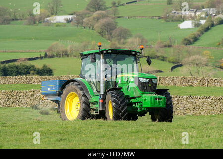 6126r John Deere répandre engrais sur les pâturages de montagne, Lancashire, Royaume-Uni. Banque D'Images