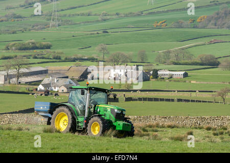 6126r John Deere répandre engrais sur les pâturages de montagne, Lancashire, Royaume-Uni. Banque D'Images