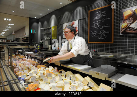 Jeune homme travaillant sur les fromages dans un supermarché Waitrose UK Banque D'Images