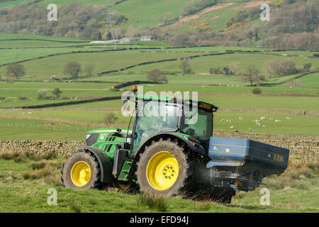 6126r John Deere répandre engrais sur les pâturages de montagne, Lancashire, Royaume-Uni. Banque D'Images