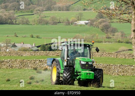 6126r John Deere répandre engrais sur les pâturages de montagne, Lancashire, Royaume-Uni. Banque D'Images