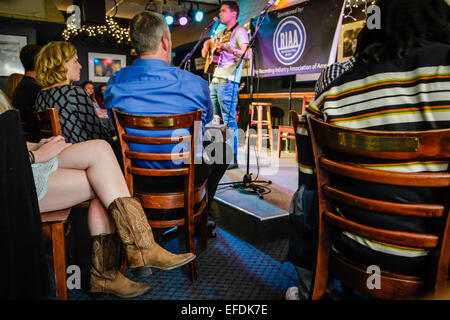 L'auteur-compositeur joue sur scène avec la jupe courte et les bottes de cowboy pour femme dans le légendaire Blue Bird café, Nashville TN, USA Banque D'Images