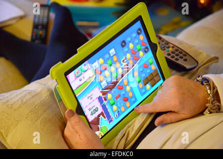 Femme jouant de Candy Crush sur son iPad, Stanwell Moor, Surrey, Angleterre, Royaume-Uni Banque D'Images