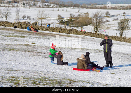 Lake District, Cumbria, Royaume-Uni. 1er février 2015. Météo France : Après la récente chute de neige, sur une journée ensoleillée mais très froid, les familles profitent de la luge sur les collines près de Caldbeck, Lake District, Cumbria, Angleterre, Royaume-Uni. Credit : Julie friteuse/Alamy Live News Banque D'Images