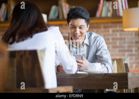 Jeune femme et l'homme parler in cafe Banque D'Images