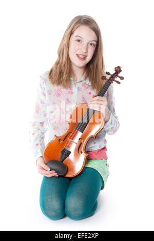 Jeune fille se trouve dans le studio contre fond blanc et tient le violon Banque D'Images