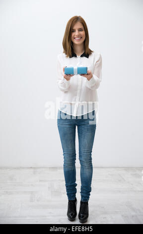 Portrait of a smiling woman standing with gift Banque D'Images