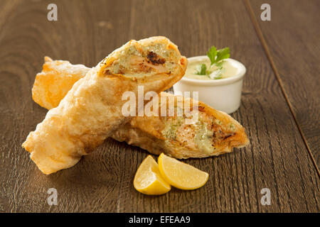 Kebab traditionnel rouleau Paratha Placez tikka wrap servi sur une plaque avec du chutney, sur un fond de bois Banque D'Images