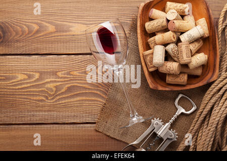 Verre à vin rouge, bouchons et tire-bouchon en bois sur fond de table with copy space Banque D'Images