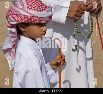 Garçon musulman en costume traditionnel avec le père et son chapelet, Al-Ain, Abu Dhabi, Émirats Arabes Unis Banque D'Images