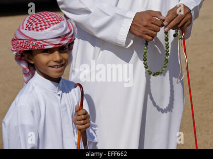 Garçon musulman en costume traditionnel avec le père et son chapelet, Al-Ain, Abu Dhabi, Émirats Arabes Unis Banque D'Images