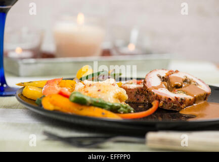Filet de porc farci grillé et servi avec des pommes de terre gratinées et des légumes grillés Banque D'Images