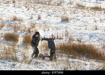 Les enfants ayant un combat de boules de neige sur la puce dans la neige, Lake District, UK Banque D'Images