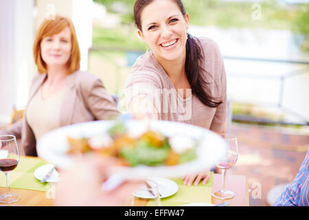 Smiling woman handing over plate Banque D'Images
