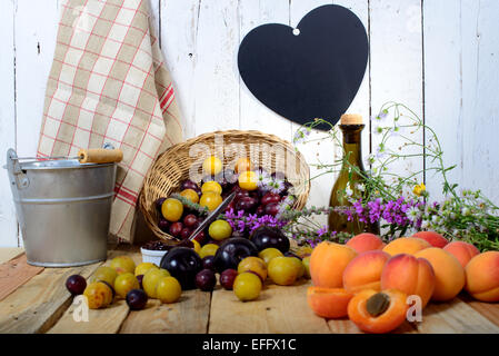 Les abricots et les prunes sur une table en bois avec coeur Banque D'Images